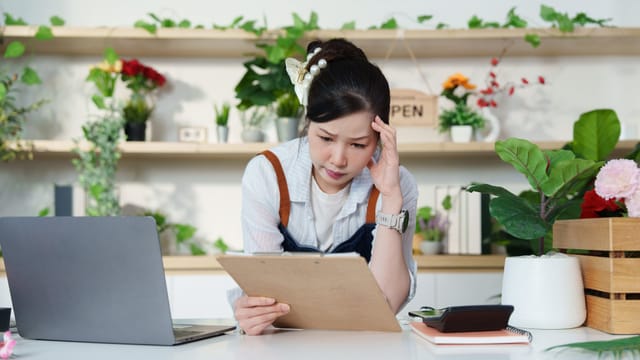 Shop owner reviewing a clipboard in her plant store